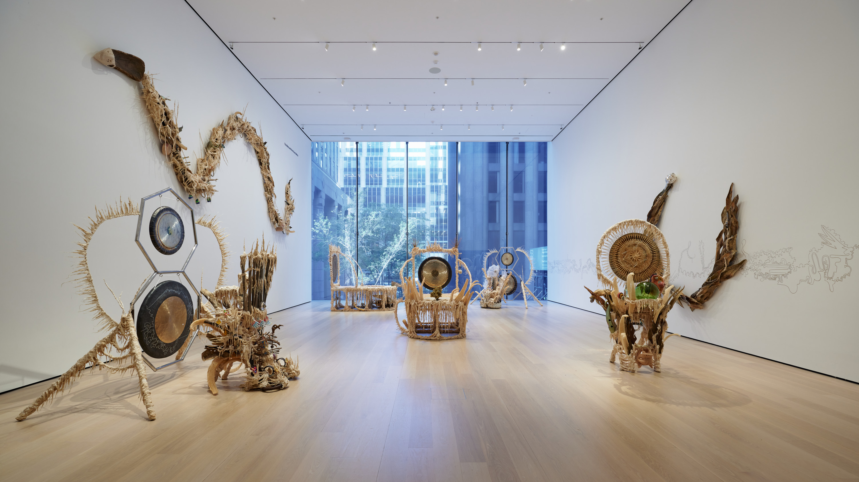 In a long room with white walls and a floor to ceiling window features cream and beige sculptures representing the artists battle with cancer.