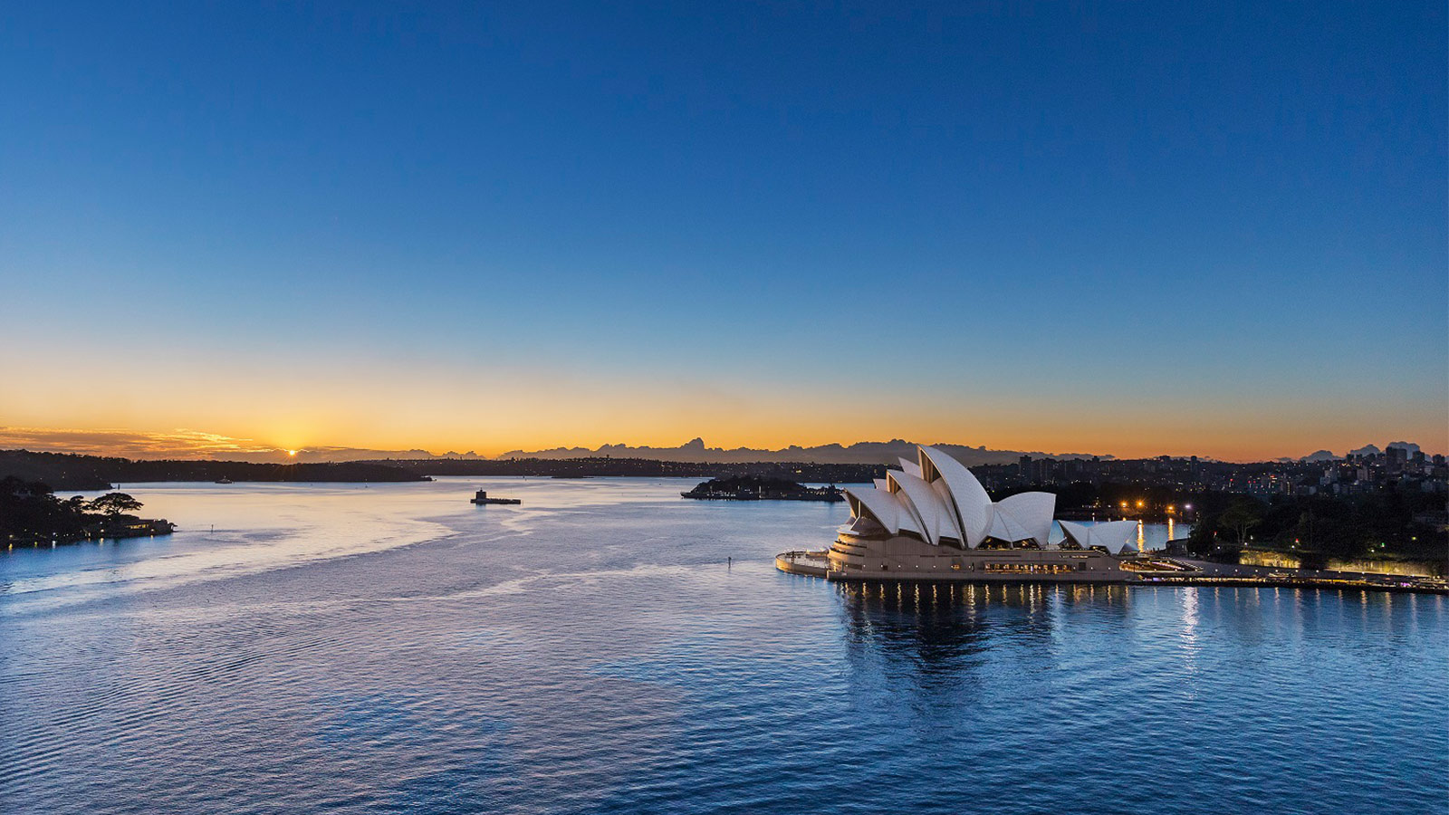 A long shot of the Sydney opera house at sunset.