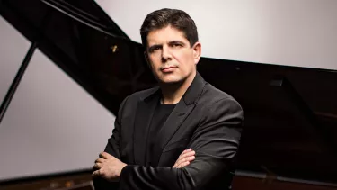 Pianist Javier Perianes sits in front of a grand piano