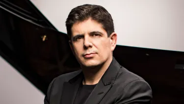 Pianist Javier Perianes sits in front of a grand piano