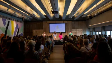 A panel of four women in the Utzon Room full of seated patrons.
