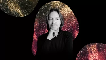 A black and white photo of Conductor Eric Whiteacre with a red and yellow sparkly background