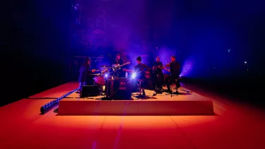 Liz Martin band performing on an elevated orange stage.