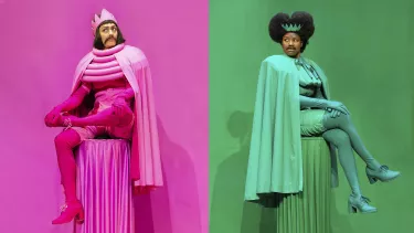 Two individuals dressed in monochromatic outfits sit on pedestals; one in pink with a crown on the left, and one in green with a crown on the right, both in similar regal poses against matching backgrounds.