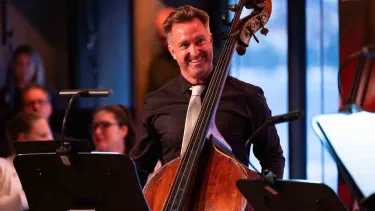 David Campbell stands with a double bass.