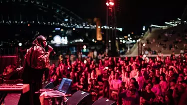 A crowd listening to a musician singing on the stage at Homeground.