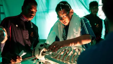 Two boys studying a skeleton.