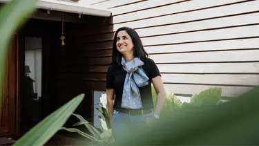 A woman in a blue scarf, smiling.