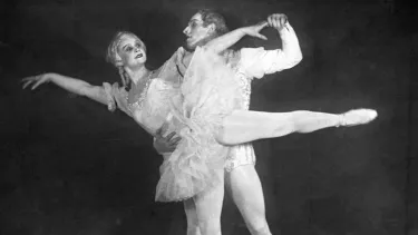 A man and woman in white outfits, dancing,