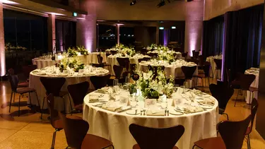 Circle tables dressed in candles and white table cloths.