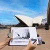 A hand drawn picture of the Sydney Opera House on a clipboard