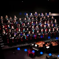 A group of people singing on stage, viewed from overhead.