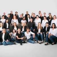A group of people posing in front of a white backdrop.