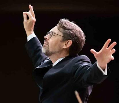 Andrey Boreyko stands with arms outstretched.