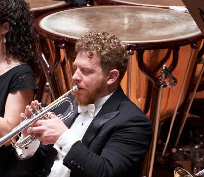 Three trumpet players of the Sydney Symphony Orchestra play the trumpet in front of the Timpani and percussion section