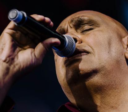 Kutcha Edwards sings with microphone in hand