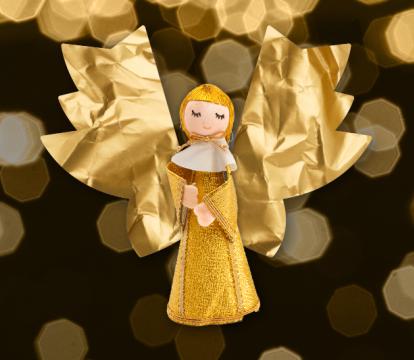 A golden doll of a Christmas Caroler with paper angel wings
