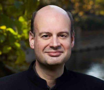 Stephen Layton stands in front of a river.