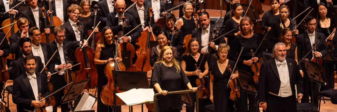 Conductor Simone Young stands with the Sydney Symphony Orchestra as they receive applause