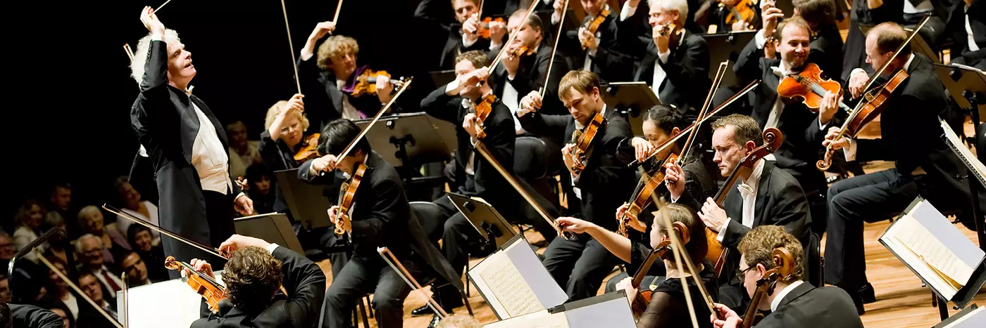 A conductor leads an orchestra on stage at the Sydney Opera House