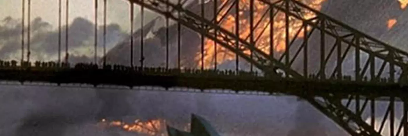 The Harbor bridge and Sydney Opera House in front of a large object on fire.