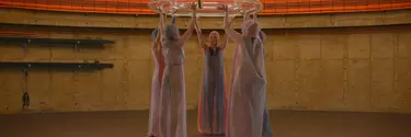 A group of women holding a swim ring above their heads in a circle.